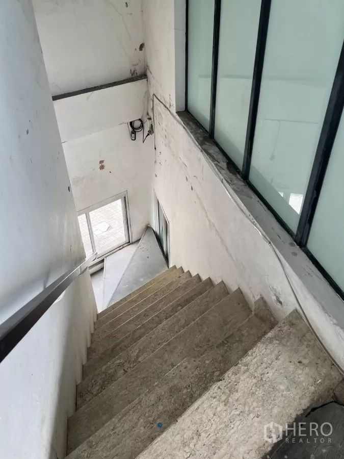 零售空间 出租 - 室内楼梯，混凝土台阶与磨砂窗通往入口。