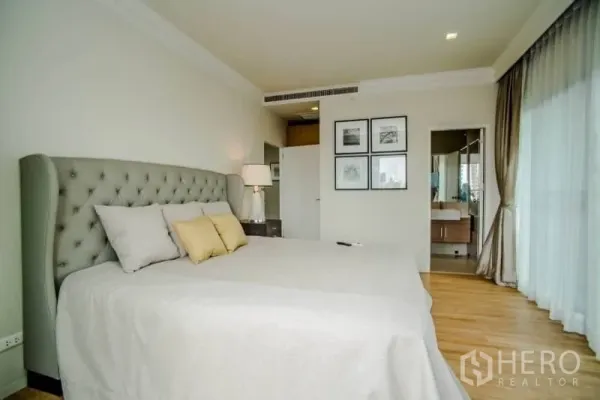 公寓 出租或出售在Watthana, Bangkok - 主卧配软包床头、大窗采光，并连通套内卫浴入口。