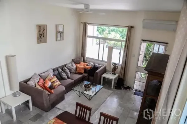 带办公室的家 出租在Min Buri, Bangkok - 一层起居区，大片窗户与转角沙发，采光充足，面向绿景