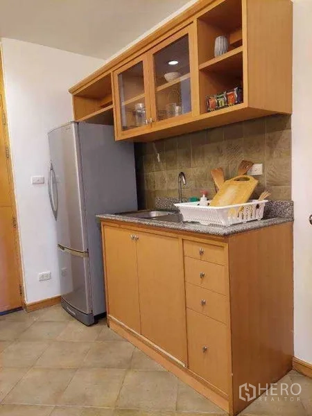 Apartment for rent - Compact kitchen corner with granite countertop, sink and tall refrigerator.
