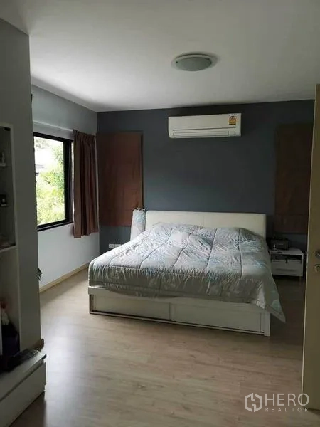 บ้าน ขายในBang Phli, Samut Prakan - ห้องนอนใหญ่ผนังสีเทา หน้าต่างบานกว้าง และเครื่องปรับอากาศติดผนัง