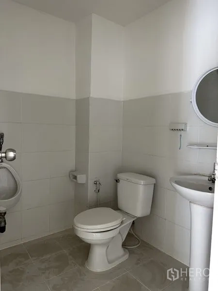 Factory for rent in Bang Sao Thong, Samut Prakan - Clean tiled bathroom with toilet, urinal and basin inside the factory.