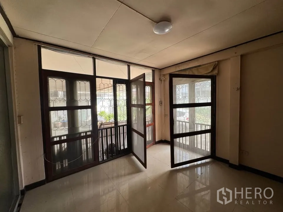 Detached House for rent or sale in Watthana, Bangkok - Upstairs sunroom with folding screen doors and gridded windows to a balcony.