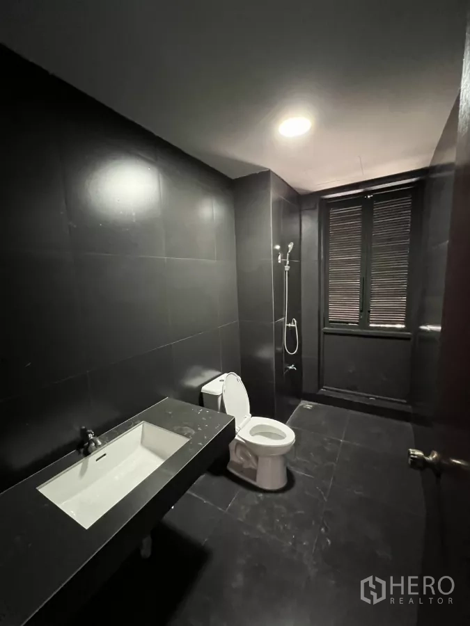 带办公室的家 出租在Pathum Wan, Bangkok - 现代黑色瓷砖卫生间，配马桶、台盆与淋浴。