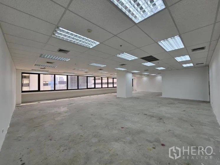 Office Space for rent in Bang Rak, Bangkok - Spacious rectangular office area with fluorescent lighting and wide window line.