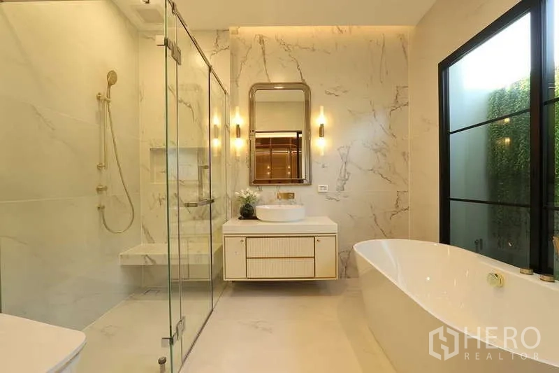 Detached House for rent in Saphan Sung, Bangkok - Luxury bathroom featuring a freestanding bathtub, glass shower and marble walls.
