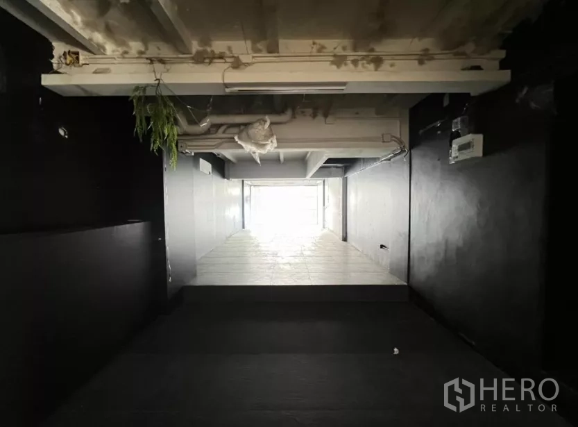 Retail Space for rent in Watthana, Bangkok - Long narrow shop space with tiled flooring leading toward the glass frontage.