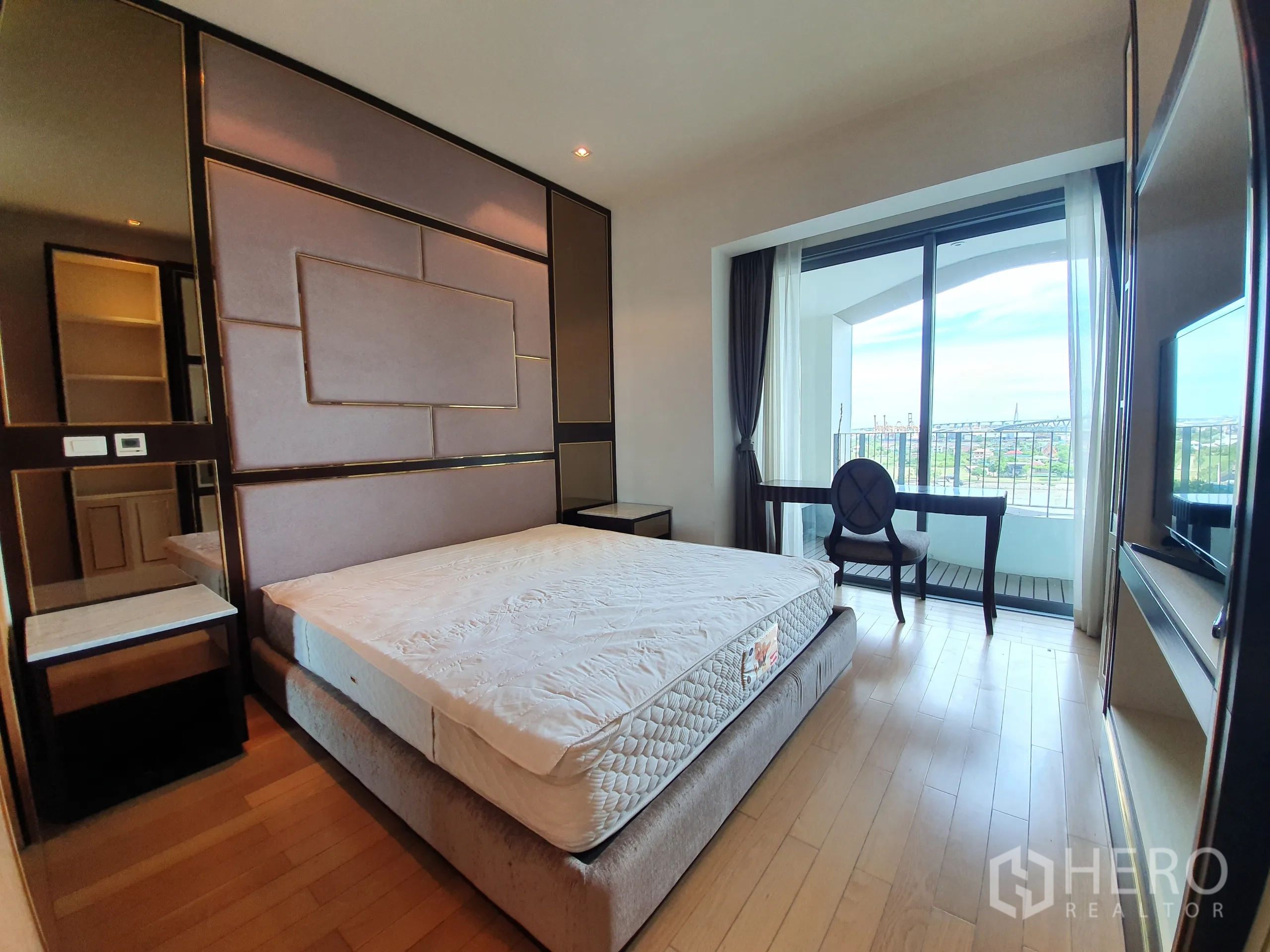 公寓 出租或出售在Yan Nawa, Bangkok - 卧室配软包背景墙与书桌，阳台门外为河景。