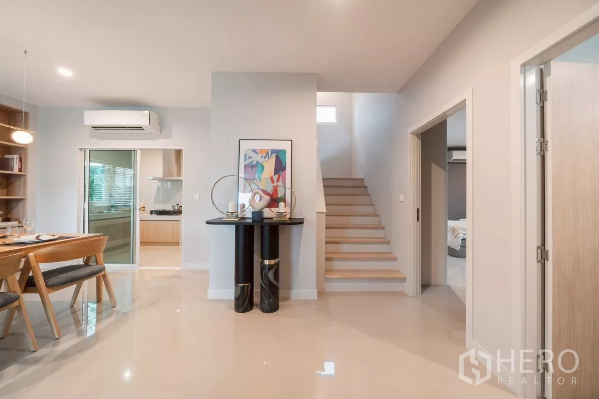 Detached House for rent in Saphan Sung, Bangkok - Ground‑floor hall with staircase, glossy tile floors and access to adjoining rooms.
