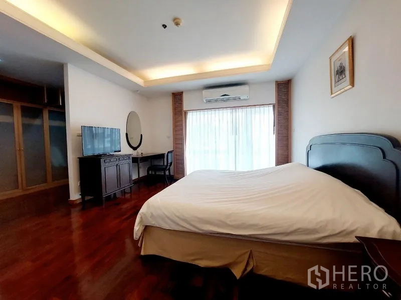 Apartment for rent - Master bedroom with king bed, TV console, writing desk, balcony door and air conditioner.