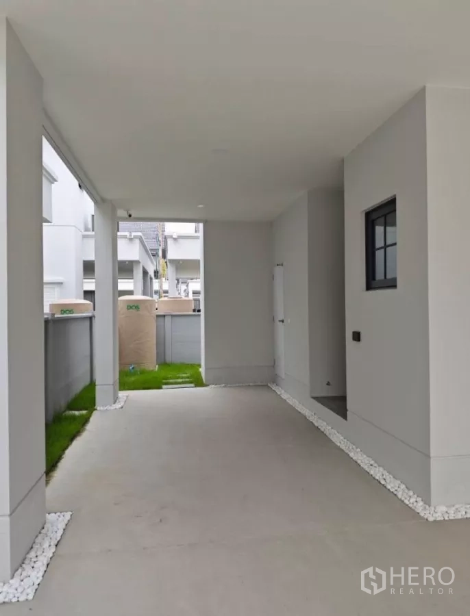 Detached House for rent in Bang Phli, Samut Prakan - Covered carport with concrete floor and side yard.