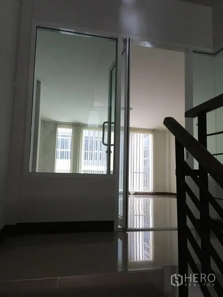 Home Office for rent in Lat Krabang, Bangkok - View from staircase to glass door office with windows and polished flooring.