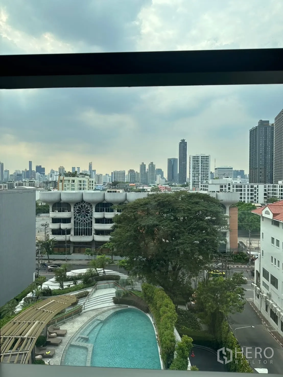 คอนโด for rent or sale in Watthana, Bangkok - วิวสระว่ายน้ำพร้อมสวนและสกายไลน์เมืองจากห้อง.