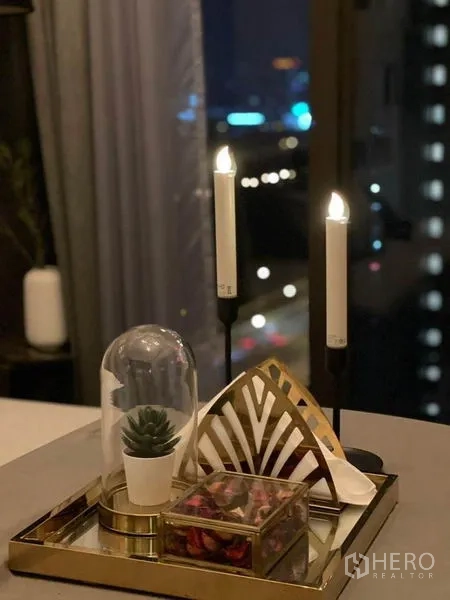 Condominium for rent in Ratchathewi, Bangkok - Decorative tray with candles and succulent by a window overlooking city lights.