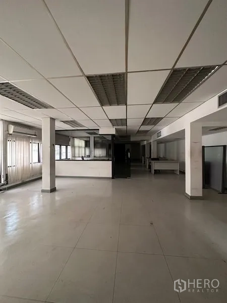 Office Space for rent in Pathum Wan, Bangkok - Spacious columned office area with fluorescent lighting and tiled floor.