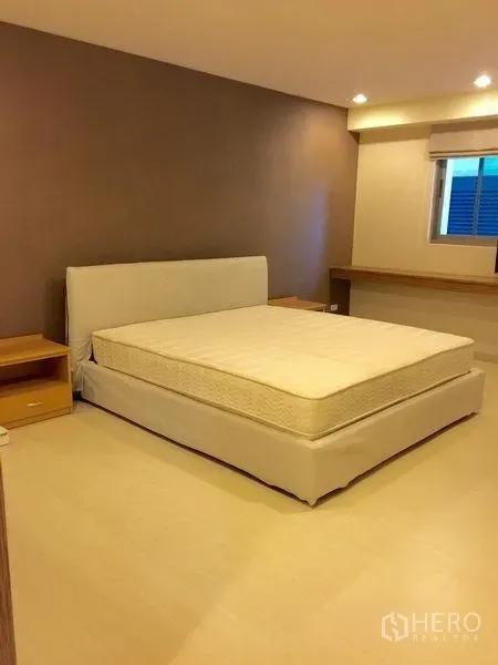 公寓 出租在Watthana, Bangkok - 宽敞卧室，特大床与极简装饰，嵌灯照明。
