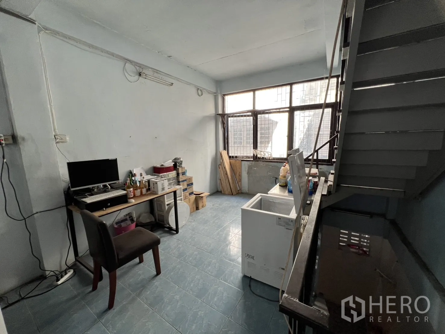 店屋 出租或出售 - 楼梯旁工作区，宽窗下放置冰柜与办公桌。