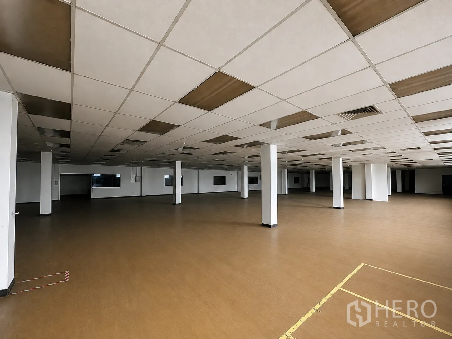 Factory for rent or sale in Wang Noi, Phra Nakhon Si Ayutthaya - Open production space with brown flooring, columns, and acoustic ceiling panels.