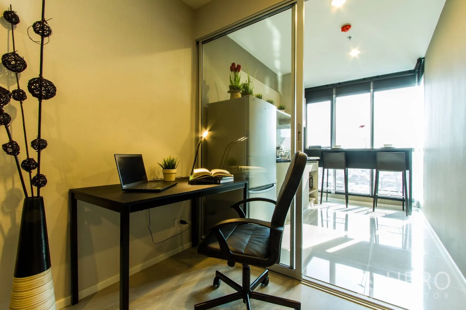 Condominium for rent or sale in Sathon, Bangkok - Bright study corner with desk and chair beside a glass partition leading to the kitchen and breakfast bar.