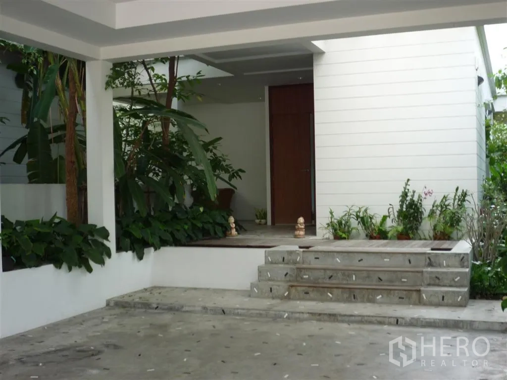 Detached House for rent in Khan Na Yao, Bangkok - Covered entry porch with steps, potted plants and lush tropical landscaping.