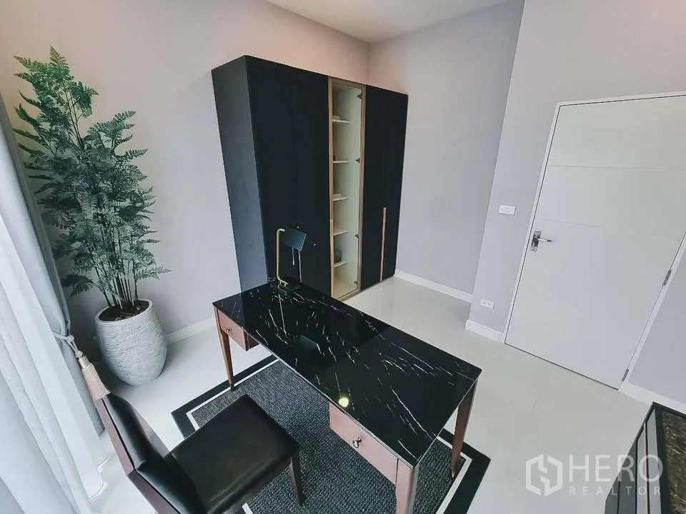 独栋房屋 for rent or sale in Bang Phli, Samut Prakan - 家庭办公室，黑色石纹书桌、柜体与大盆栽靠窗。