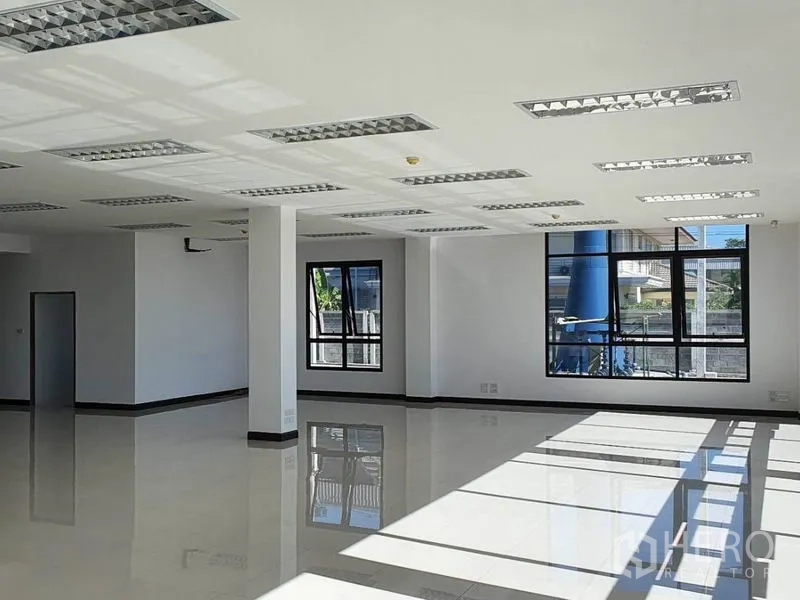 货栈 出租在Samut Prakan - 明亮的办公室内部，瓷砖地面与栅格灯具。