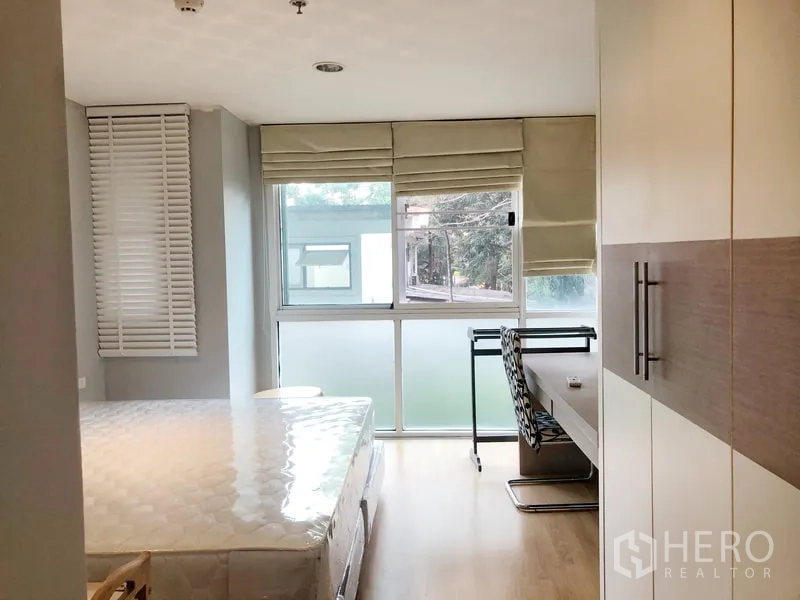 Condominium for rent or sale in Khlong Toei, Bangkok - Second bedroom with built-in wardrobe, study desk and wide windows.
