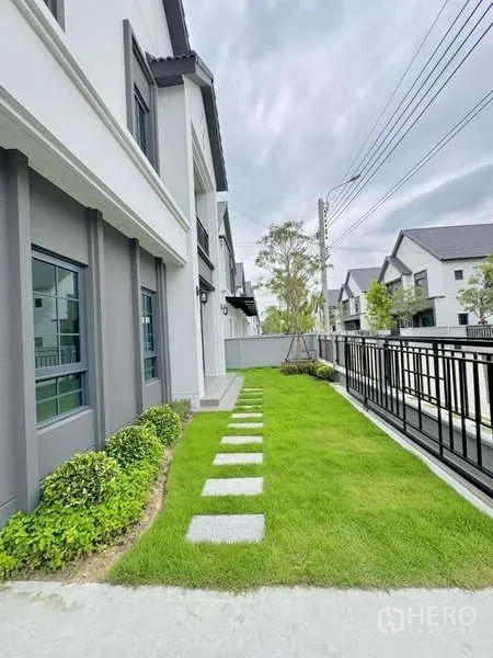独立式住宅 出售在Bang Phli, Samut Prakan - 侧院草坪，踏步石小径沿屋侧延伸