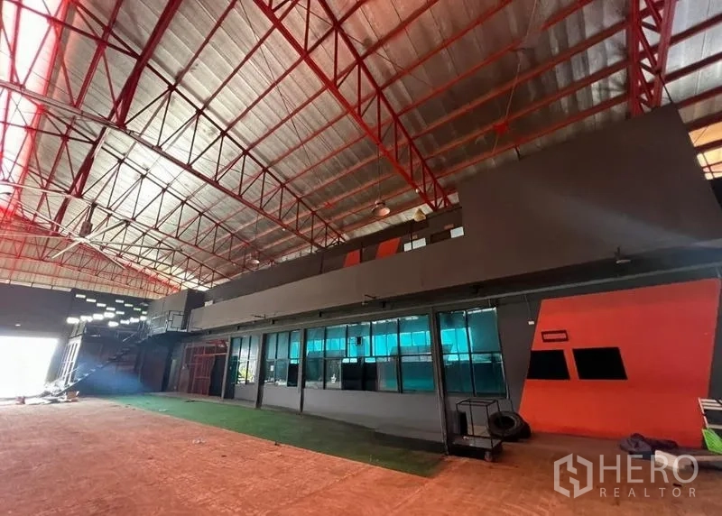 Showroom for rent in Mueang Samut Prakan, Samut Prakan - Showroom interior with office windows, orange accent wall and high ceiling
