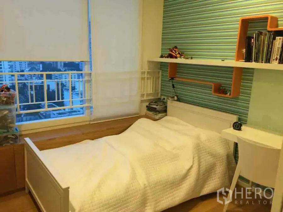 Condominium for rent or sale in Watthana, Bangkok - Bright bedroom with a single bed, built-in shelves and a city-view window in an Asok, Watthana condominium.