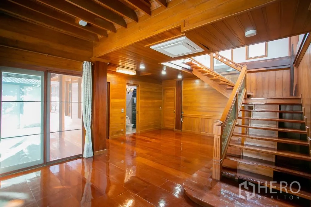 独栋房屋 for rent or sale in Huai Khwang, Bangkok - 起居区另一角度，可见楼梯、推拉玻璃门与卫生间。