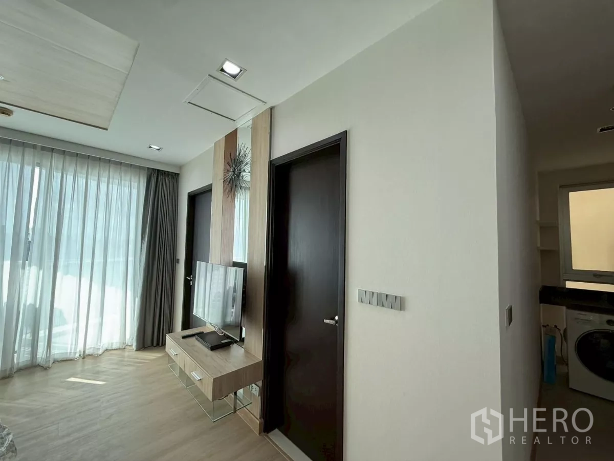 คอนโด ให้เช่าในWatthana, Bangkok - ผนังทีวีพร้อมตู้ลอย หันสู่หน้าต่างบานใหญ่ ใกล้ทางเข้าครัว