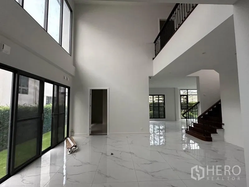 Detached House for sale in Lat Krabang, Bangkok - Bright double-height living area with large sliding windows and glossy marble-look floors.