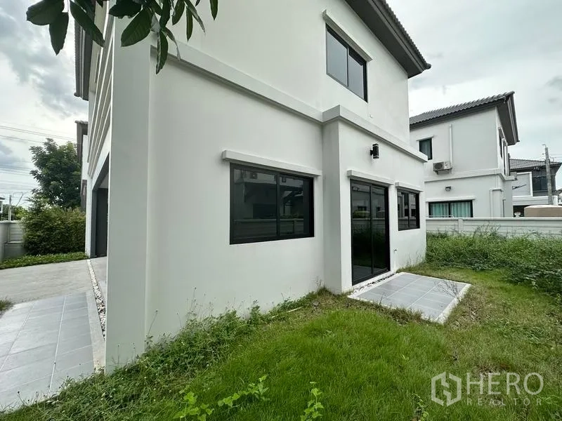 独立式住宅 出售在Khlong Sam Wa, Bangkok - 后院草地与滑门露台和围栏