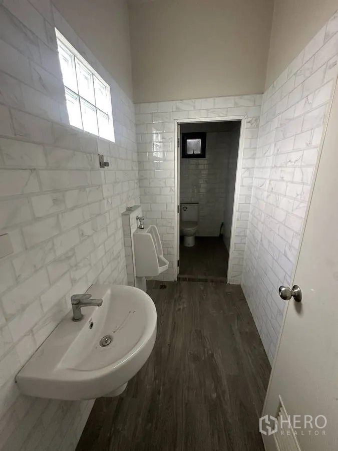Home Office for rent in Taling Chan, Bangkok - Modern restroom with white subway tiles, urinal and separate toilet cubicle.