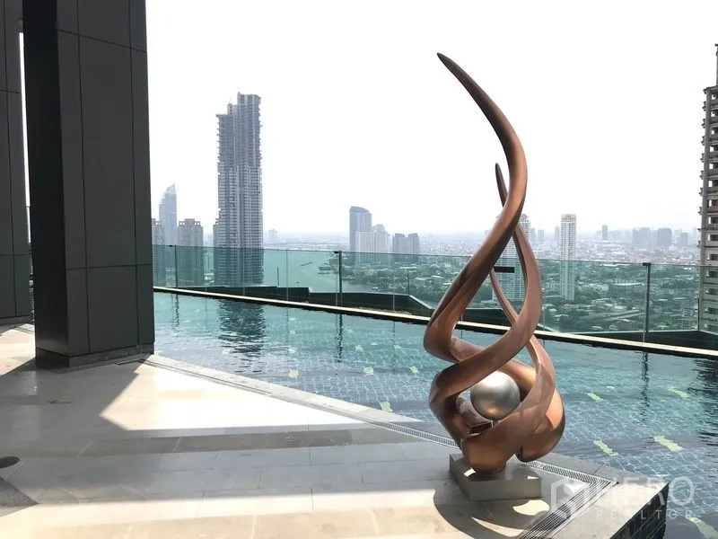 Condominium for rent in Sathon, Bangkok - Infinity-edge rooftop swimming pool with sculptural art and sweeping city panorama.