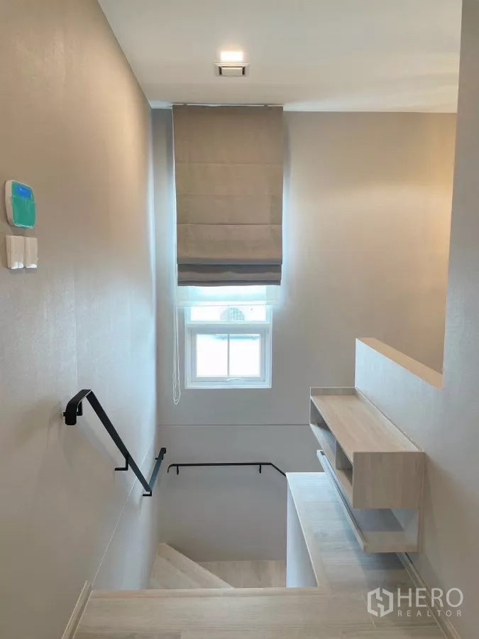 Detached House for rent in Bang Phli, Samut Prakan - Staircase with window, handrails, and built-in shelving at the landing.