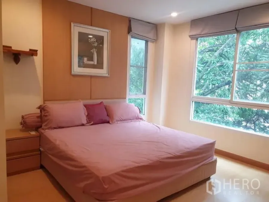 Condominium for rent in Watthana, Bangkok - Bright master bedroom with large windows and leafy view in an Ekkamai-area condo.