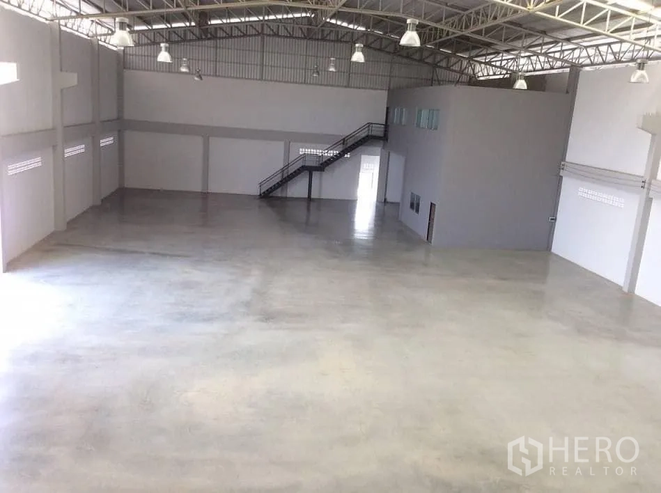Factory for rent or sale in Bang Sao Thong, Samut Prakan - Panoramic view of warehouse floor with office mezzanine and lighting.