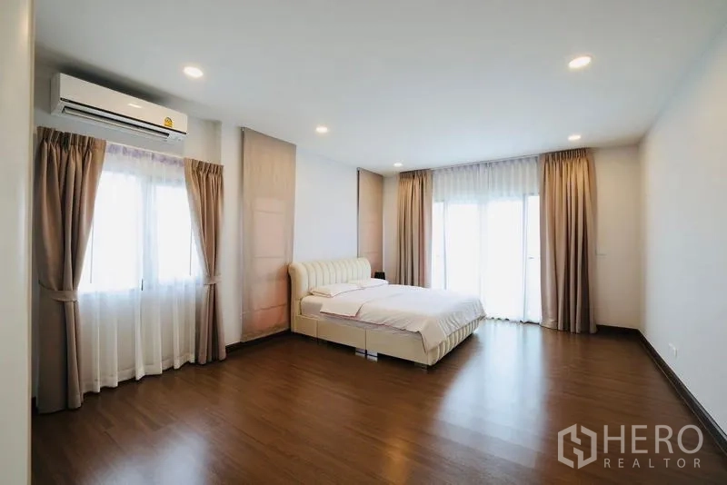 独立式住宅 出租在Bang Phli, Samut Prakan - 超大主卧，木地板、空调与落地阳台窗。