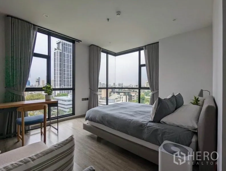 公寓 出租在Watthana, Bangkok - 主卧转角落地窗，俯瞰城市天际线。