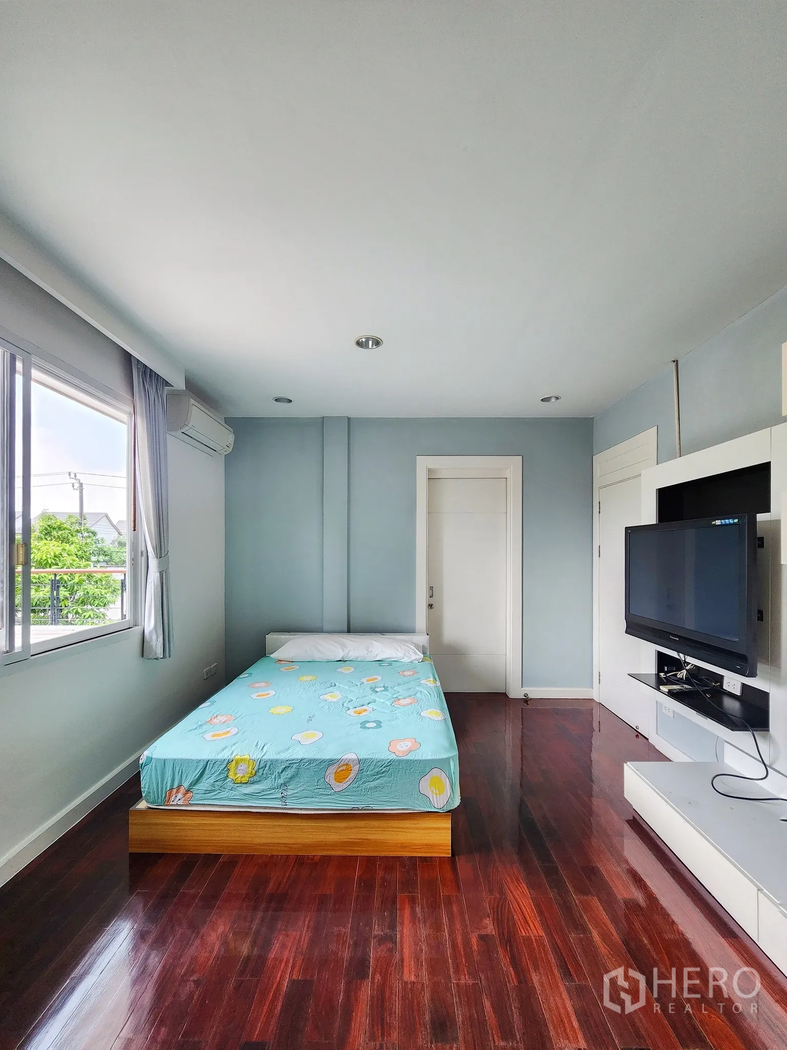Detached House for rent in Bang Kapi, Bangkok - Third bedroom with TV wall, white shelving and blue bedding.