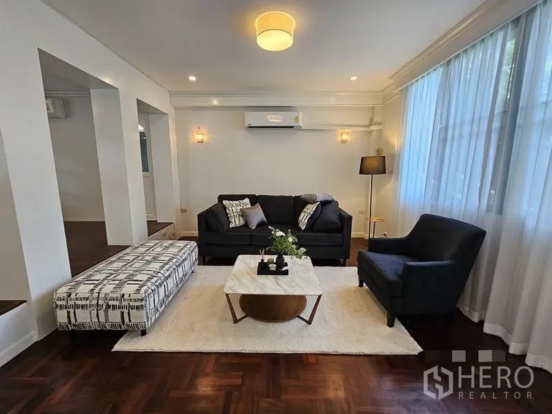 บ้าน ให้เช่า - ห้องรับแขกแบบเป็นทางการ โซฟาชุด ออตโตมัน และไฟดาวน์ไลท์บรรยากาศอบอุ่น