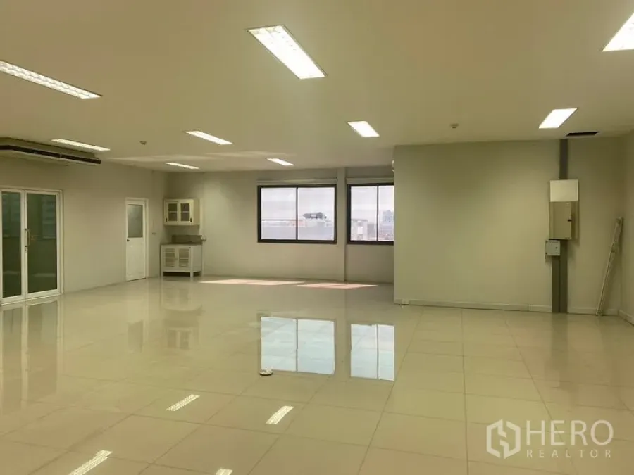 办公空间 出租在Bang Na, Bangkok - 开放式办公室，窗外城市景观，角落茶水间与充足采光。