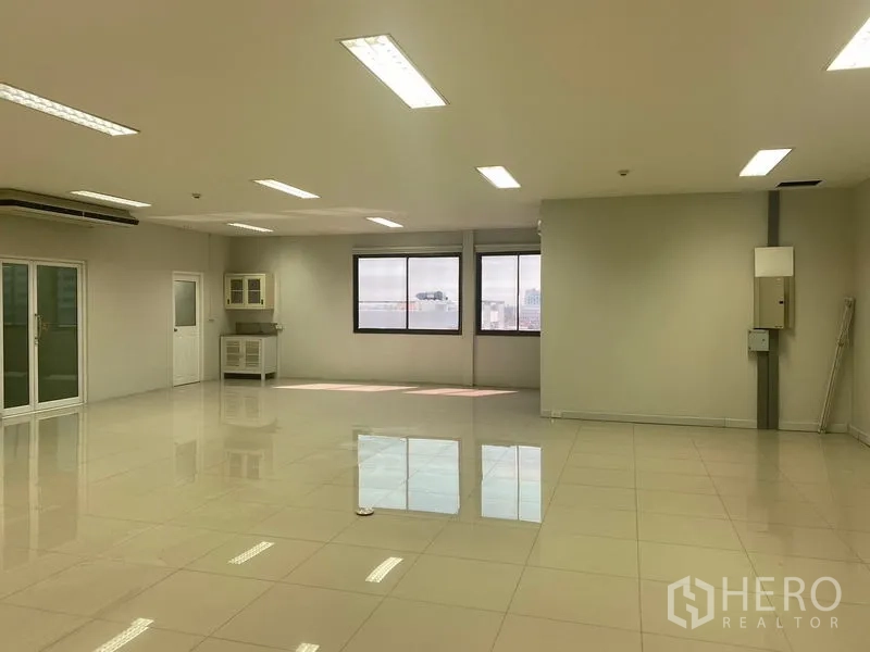 办公空间 出租在Bang Na, Bangkok - 开放式办公室，窗外城市景观，角落茶水间与充足采光。