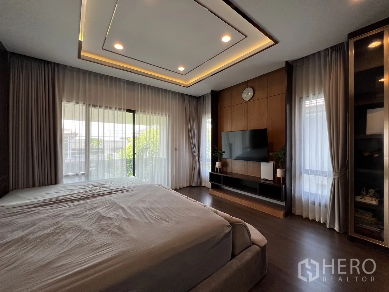 บ้าน ให้เช่าหรือขายในBang Kapi, Bangkok - ห้องนอนใหญ่ เตียงคิง ทีวีผนัง และประตูกระจกสู่ระเบียง