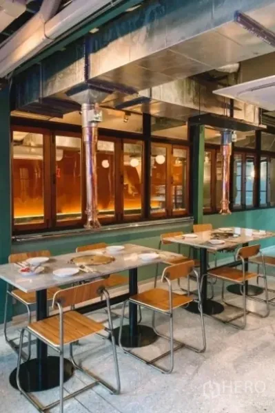 独立式住宅 出售在Khlong Toei, Bangkok - 室内用餐空间，石材餐桌、木椅与外露金属排烟管道。