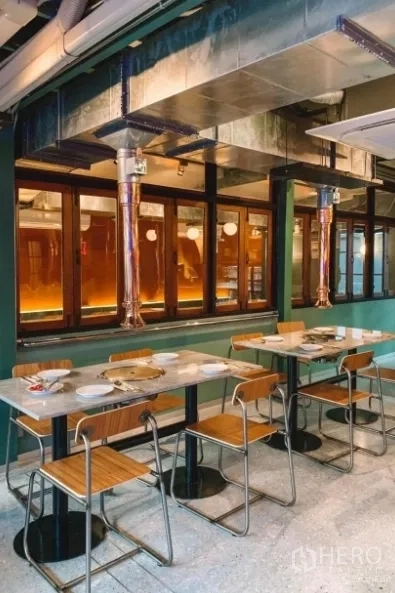 独立式住宅 出售在Khlong Toei, Bangkok - 室内用餐空间，石材餐桌、木椅与外露金属排烟管道。