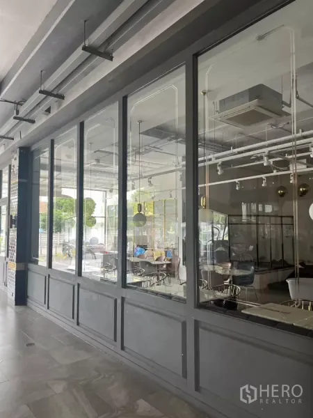 Retail Space for rent in Khlong Toei, Bangkok - Close-up of floor-to-ceiling windows showing cafe-style interior and ceiling services.