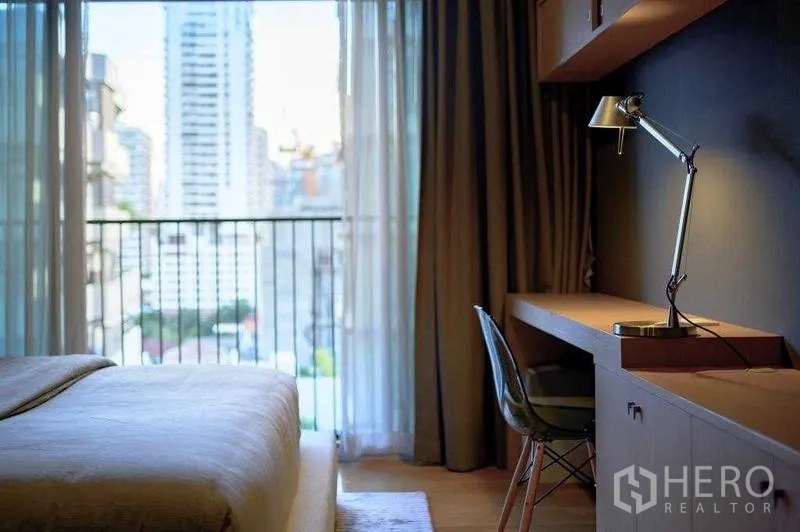คอนโด ให้เช่าในWatthana, Bangkok - โต๊ะทำงานในห้องนอนหันสู่ระเบียง มองวิวสกายไลน์ผ่านผ้าม่านบาง
